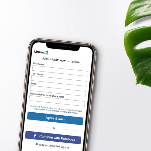 A smartphone open to the signup page for the social media platform LinkedIn