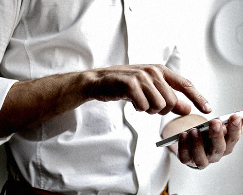 Man in a white shirt using a smartphone