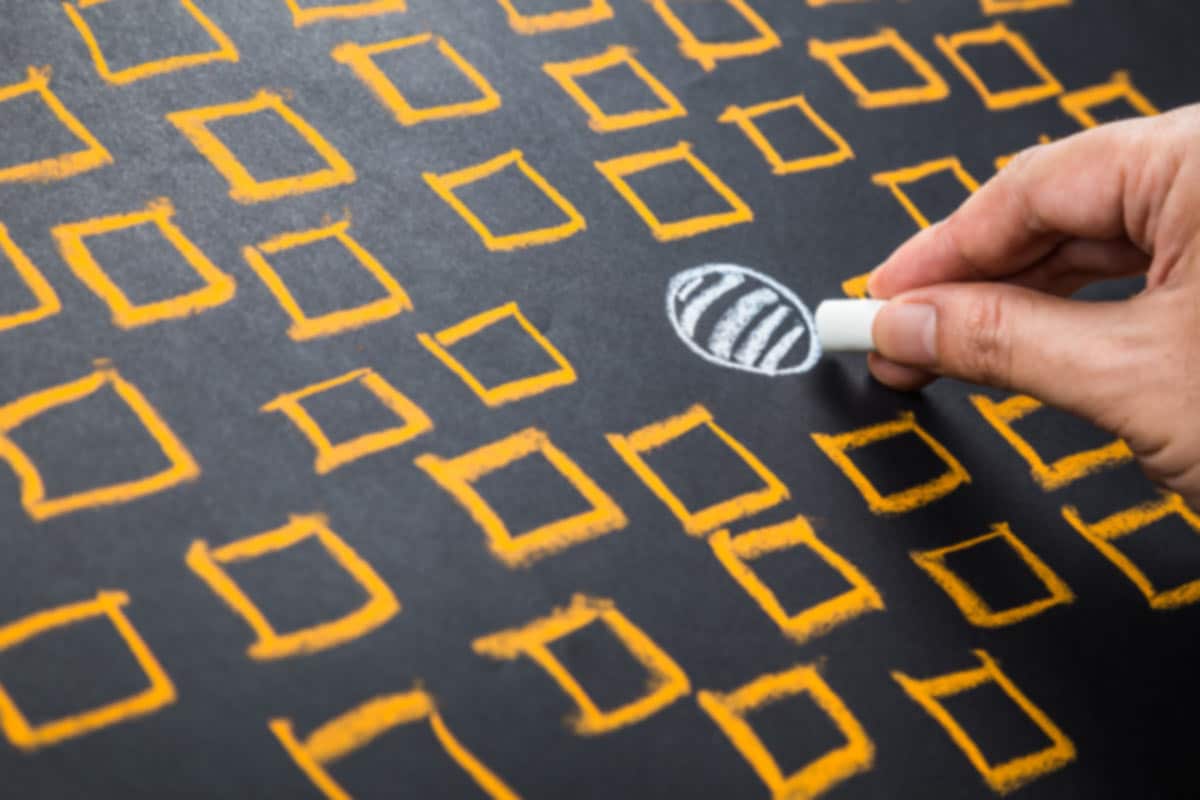 A person drawing a white circle in a field of yellow squares