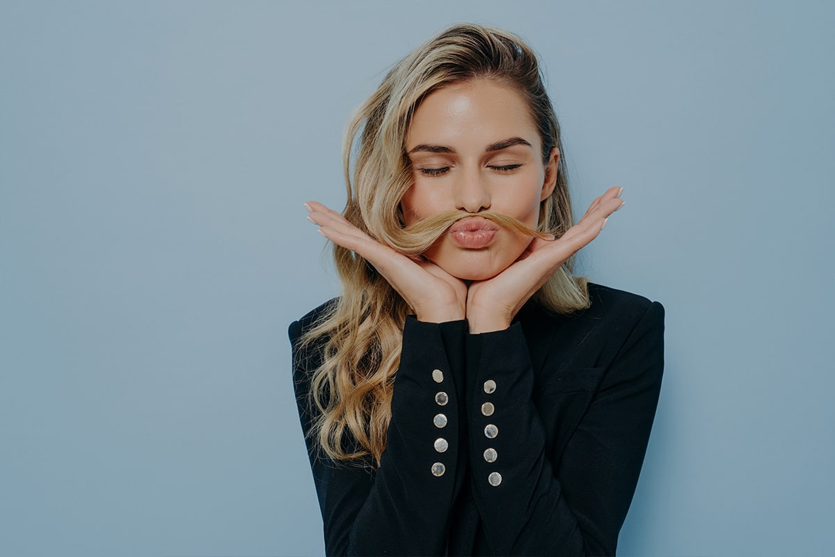 Woman using her hair to make a moustache